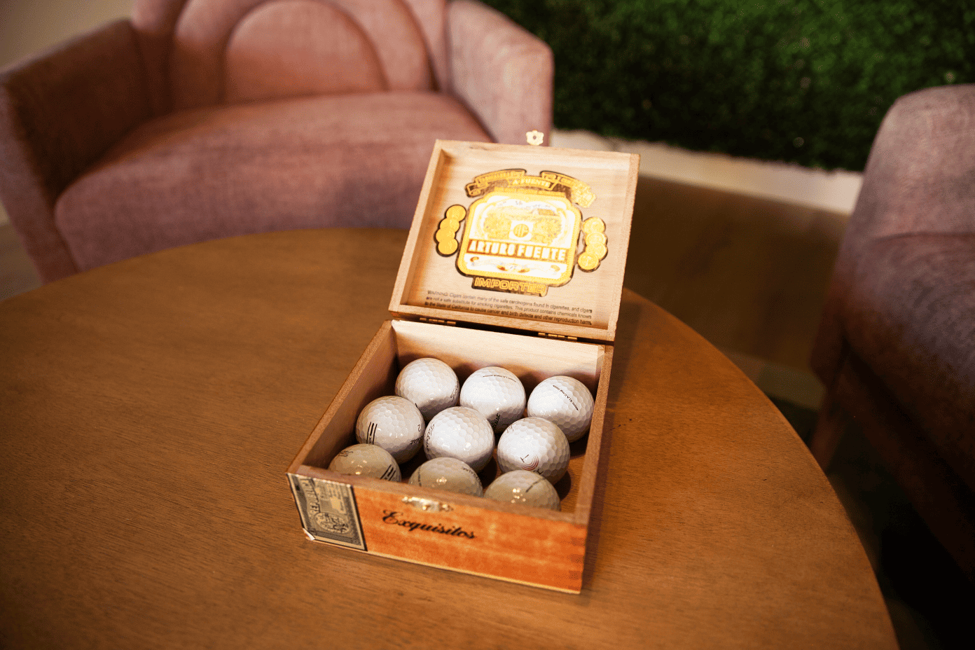 Cigar box filled with golf balls on table